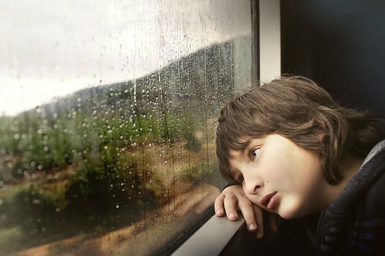 電車の窓から外を眺める女性